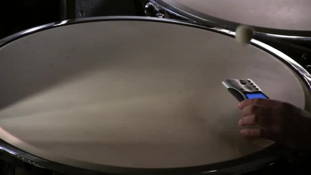 Baterista sintoniza tambor con afinador antes del concierto
 - Imágenes, Vídeo