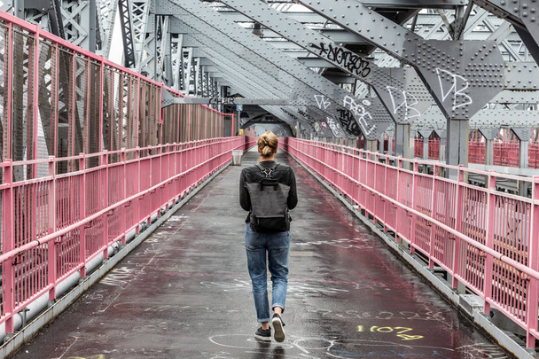 ウィリアムズバーグ橋、ブルックリン、ニューヨーク市、米国の自転車レーンを歩いているカジュアルな女性を一人します。 - 写真・画像