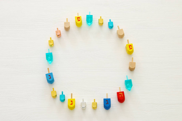 Image of jewish holiday Hanukkah with wooden dreidels colection (spinning top) over white background - Photo, Image