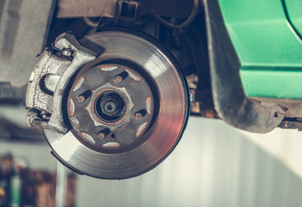 Damaged Car Brake Disc Awaiting Replacement in Auto Service. Automotive Industry. - Photo, Image