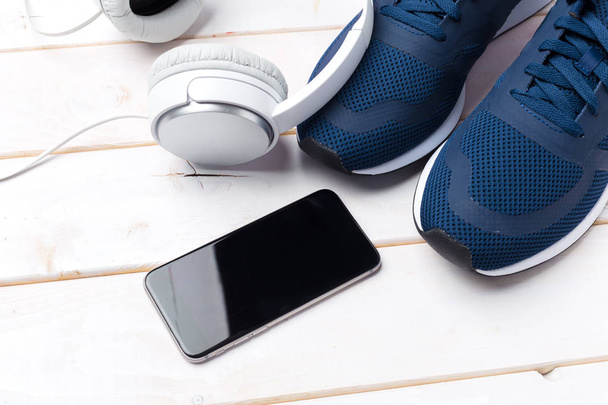 Sneakers and mobile phone with headphones - Foto, afbeelding