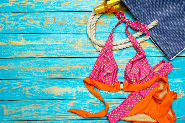 Composition with swimsuit on color wooden background - Фото, зображення