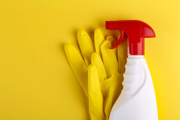 spray with detergent and gloves set on a yellow background. space for tex - Foto, afbeelding
