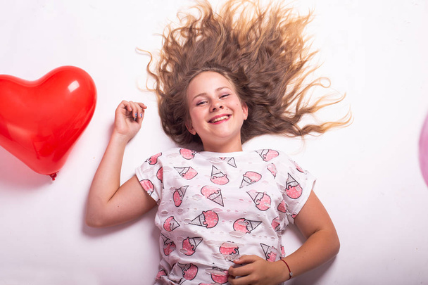 girl with balloons, child with balloons, child with balloons lying on white background - Foto, afbeelding