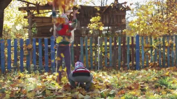 Rural, funny kids, brother and sister throw up autumn leaves - Footage, Video