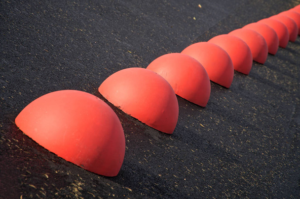 Sınırlayıcılar - kırmızı beton hemisferlerin asfaltta otopark. Trafik kısıtlama.                             - Fotoğraf, Görsel