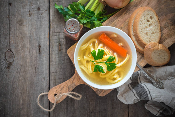 Chicken soup with noodles and carrot in white bowl. - Foto, Imagem