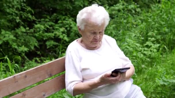 oude oma kijkt naar Internet smartphone - Video