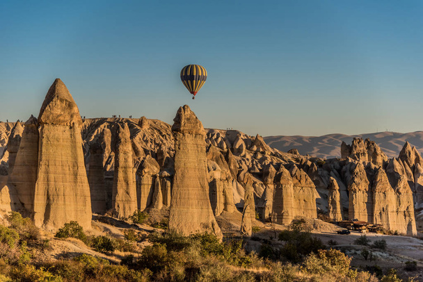 Globo de aire caliente volando sobre una formación única de rocas en Capadocia, Turquía
 - Foto, Imagen
