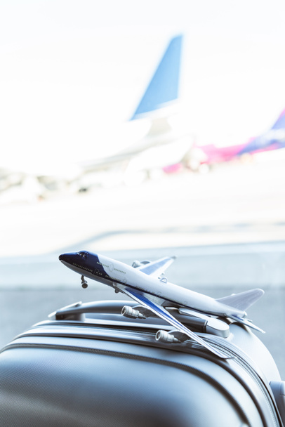 primer plano del modelo de avión pequeño en la maleta gris en el aeropuerto
 - Foto, Imagen