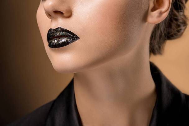 close up of young beautiful woman with glittery black lips - Foto, Imagem