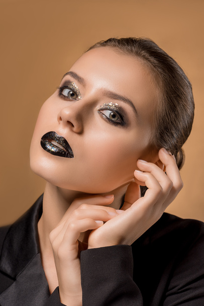 young beautiful woman with glittery makeup and hands near face - Fotografie, Obrázek