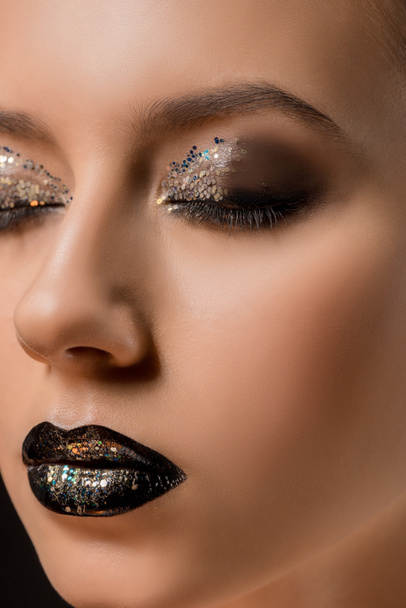 close up of young beautiful woman with glittery makeup and closed eyes - Foto, afbeelding