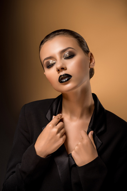 young beautiful woman with glittery makeup holding black jacket - Foto, imagen