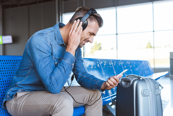 Homme attendant à l'aéroport et écoutant de la musique
 - Photo, image