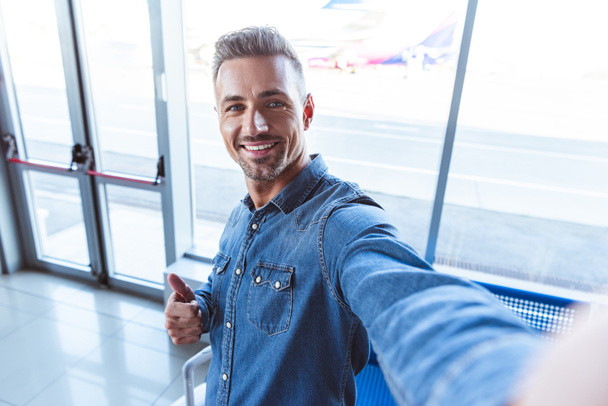 Handsome man taking selfie in the airport - Photo, Image