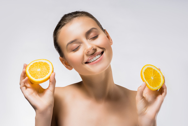 young smiling woman with closed eyes and orange slices - Foto, afbeelding