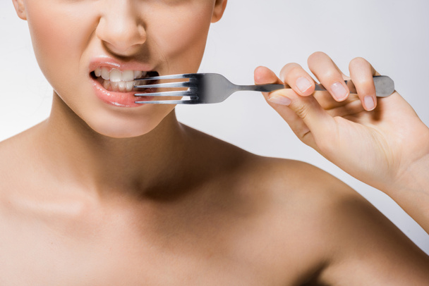 joven hermosa mujer sosteniendo tenedor de plata cerca de los dientes
  - Foto, imagen