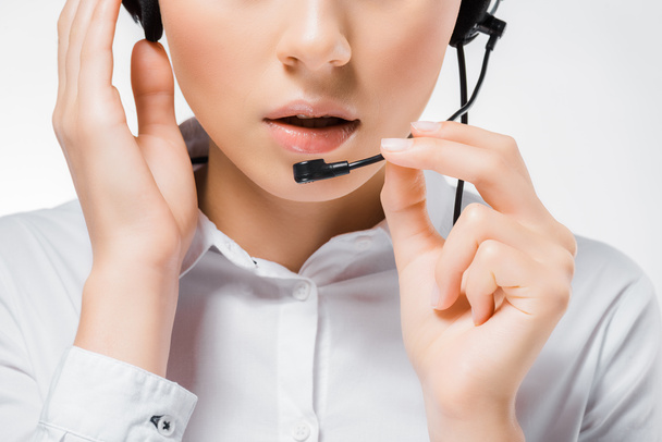 close up of young call center operator touching headset and speaking in microphone - Photo, Image