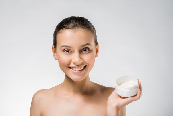 young beautiful woman holding white body cream  - Фото, изображение
