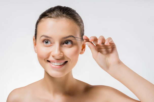 young smiling woman holding metal tweezers near face  - Photo, Image