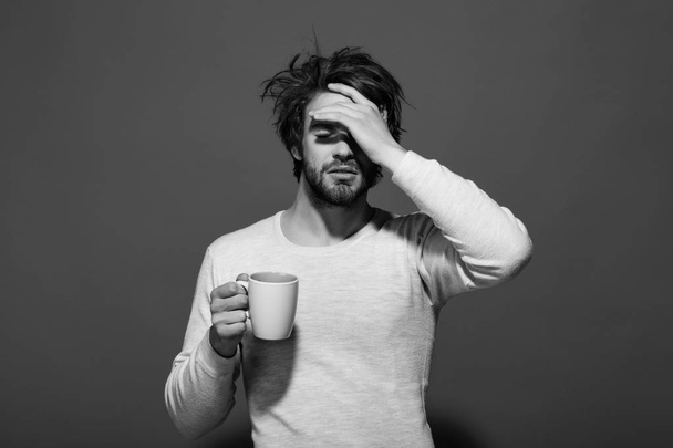 sleepy tired man with headache hold cup of tea - Φωτογραφία, εικόνα