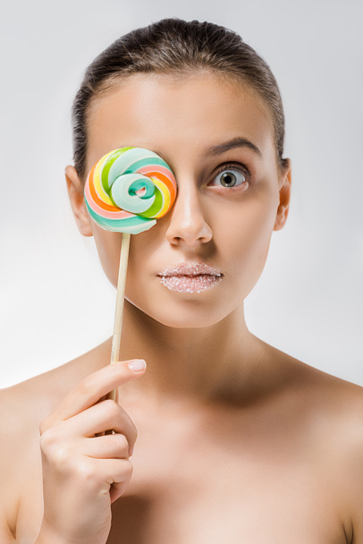 young attractive woman with sugar on lips hiding behind colored lollipop - Fotografie, Obrázek