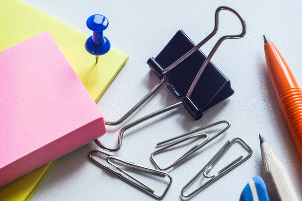 On the table, business items, pen and pencil with an elastic band. Paper clips buttons and other office. - Photo, image