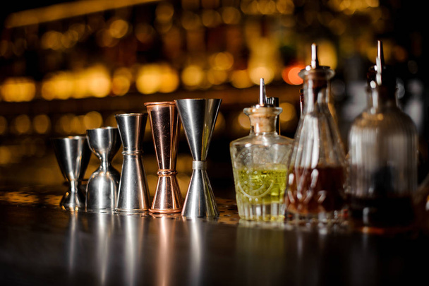 Barman equipment such as measuring cups and essence on the bar counter - Fotó, kép