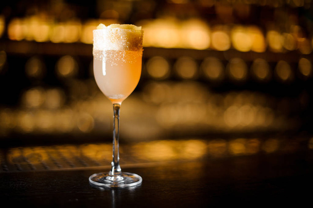 White achoholic drink with scum in the cocktail glass decorated with brown sugar and orange zest - 写真・画像