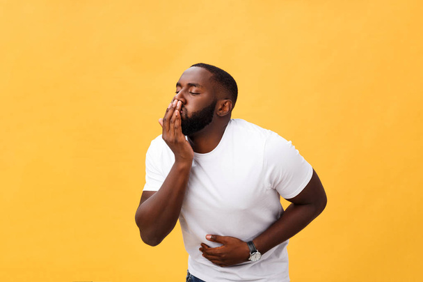 Jeune homme afro-américain portant un t-shirt blanc avec la main sur le ventre parce que les nausées, la maladie douloureuse se sentent mal. Concept Ache
 - Photo, image