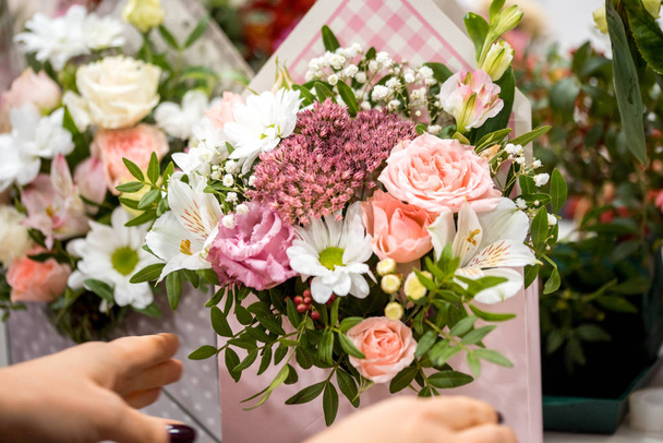 Male florist creating beautiful bouquet in flower shop, close up. - Photo, image