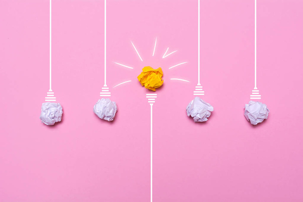 Creative idea of crumpled paper. A burning light bulb on a pink background. Education concept. - Photo, Image
