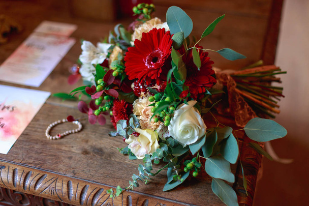 Wedding bouquet of flowers including Red hypericum, Roses, Lilies of the valley, mini Roses, Seeded Eucalyptus, Astilbe, Scabiosa, Pieris, and ivy - Foto, Bild