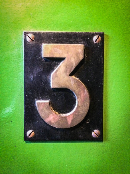 3-as szám jele, száma három fém jel zöld háttér - Fotó, kép