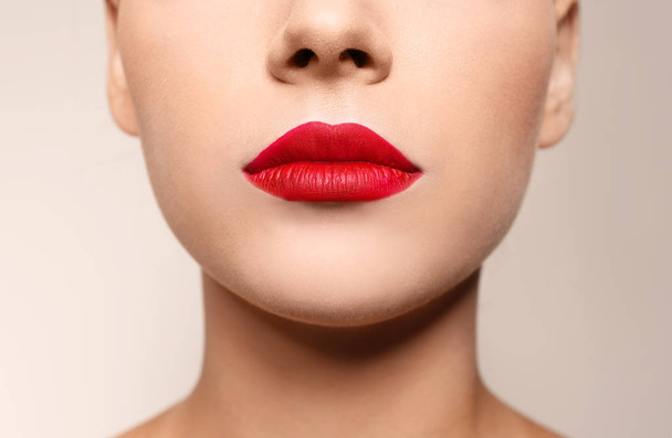 Beautiful young woman with red lips on color background, closeup - Foto, Imagem
