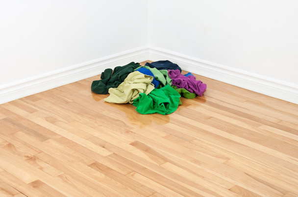 Montón de ropa de colores en la esquina de la habitación
 - Foto, imagen