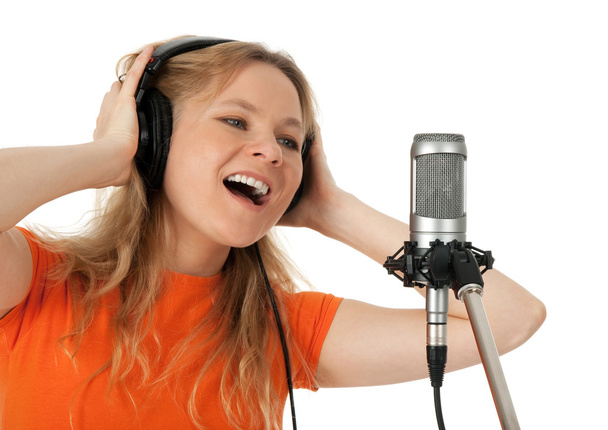 νεαρή γυναίκα στο πορτοκαλί τραγούδι t-shirt με το μικρόφωνο - Φωτογραφία, εικόνα