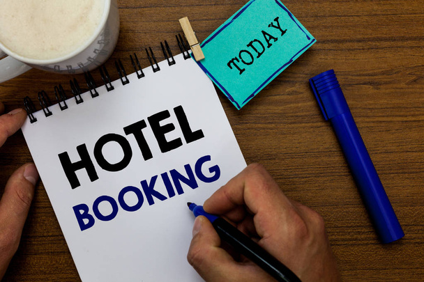 Writing note showing Hotel Booking. Business photo showcasing Online Reservations Presidential Suite De Luxe Hospitality Man holding marker notebook clothespin reminder wooden table coffee. - Photo, Image