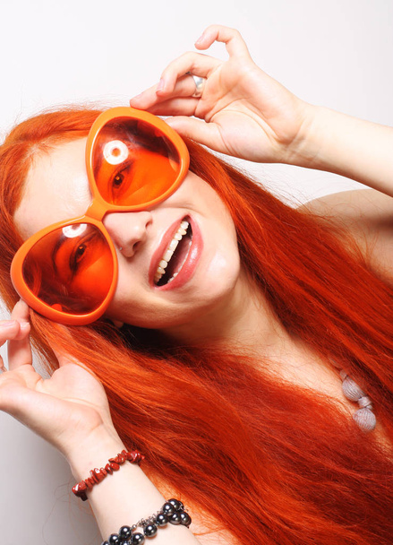 смішна руда жінка у великих помаранчевих окулярах
 - Фото, зображення