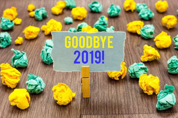 Text sign showing Goodbye 2019. Conceptual photo New Year Eve Milestone Last Month Celebration Transition Clothespin holding gray note paper crumpled papers several tries mistakes. - Photo, Image