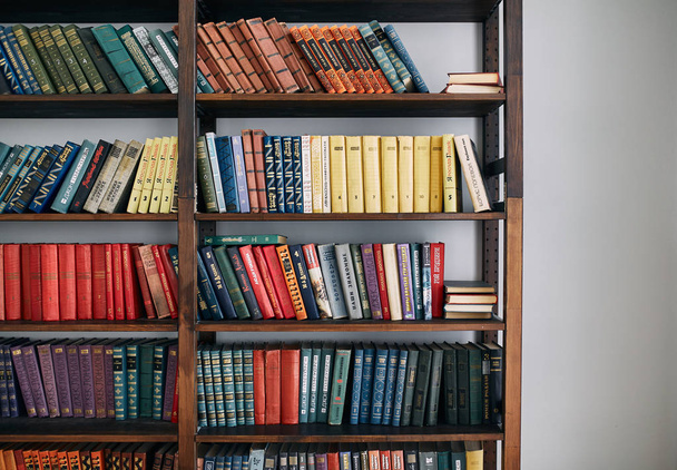 Bookcase with old books on the shelves - Valokuva, kuva