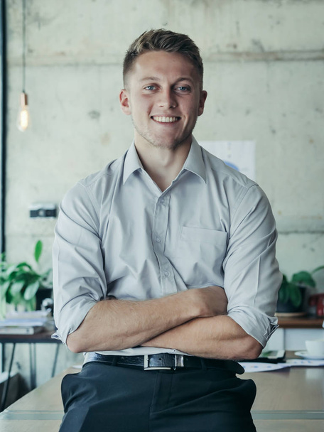 Giovane uomo d'affari di successo start up, braccio incrociato e sorridente sul posto di lavoro
 - Foto, immagini
