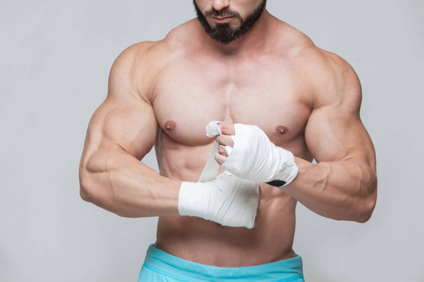 Muscular Fighter kickbox With white Bandages against the grey background - Fotoğraf, Görsel