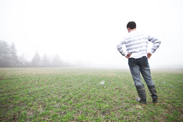 Young man In the foggy field - Fotoğraf, Görsel
