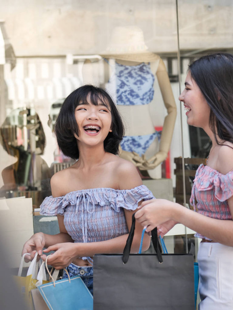 Happy Asian adolescente meninas andando e segurando sacos de compras juntos, conceito de estilo de vida
. - Foto, Imagem