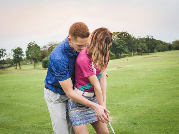 Golfer teaching his girlfriend how to play golf, lifestyle concept. - 写真・画像
