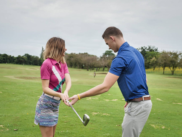 Golfer teaching his girlfriend how to play golf, lifestyle concept. - Fotó, kép