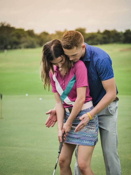 Golfer teaching his girlfriend how to play golf, lifestyle concept. - Valokuva, kuva