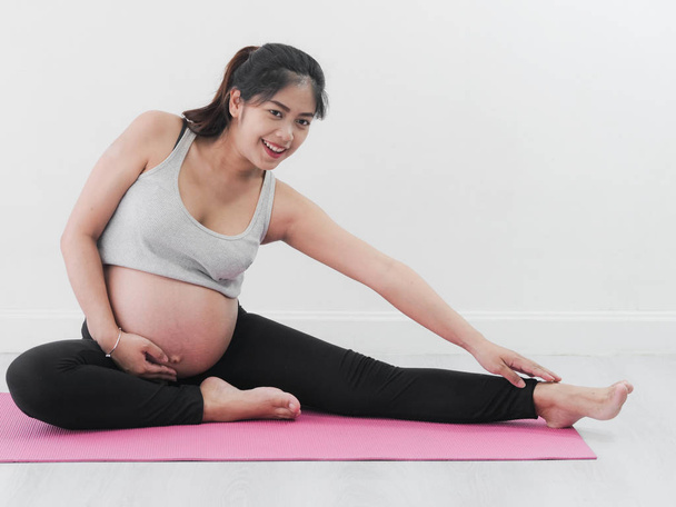 Asian pregnant woman doing yoga at home, lifestyle concept. - 写真・画像